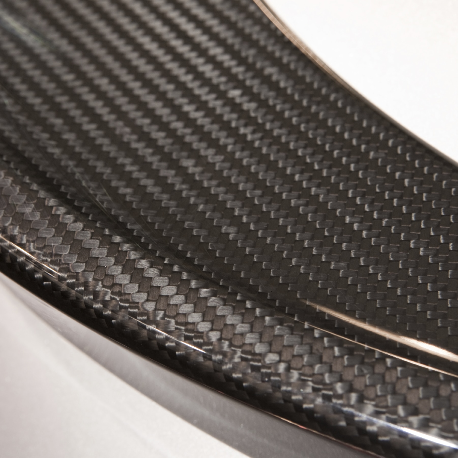 Detail of a carbon fiber molded element, with close up of the textured surface and pattern of the high technology material.